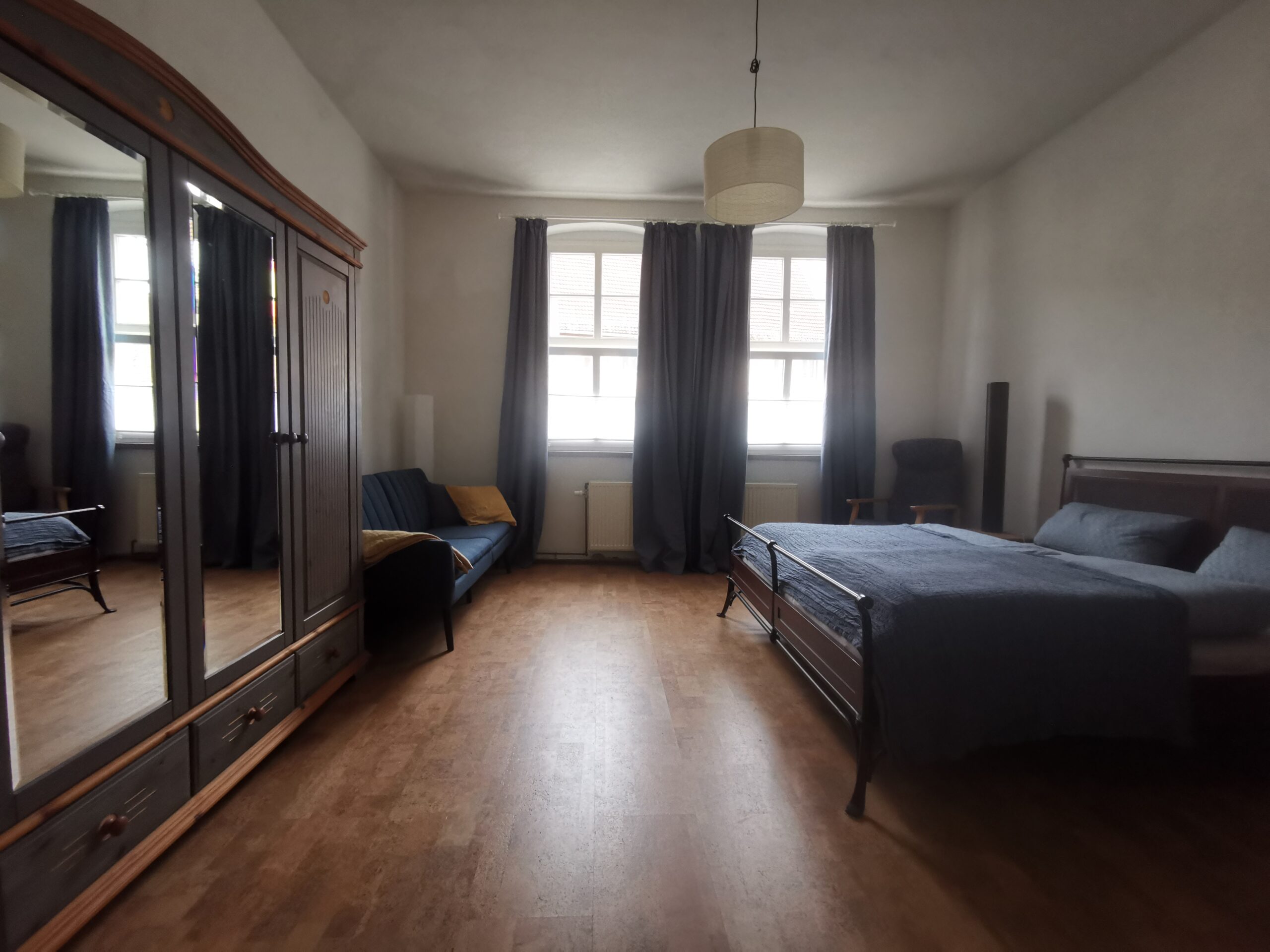 großes Schlafzimmer mit Doppelbett, Schlafsofa und Kinderbett